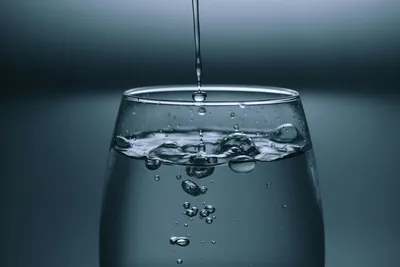Glass of clear water being filled from a kitchen tap, representing chlorine in Australian tap water