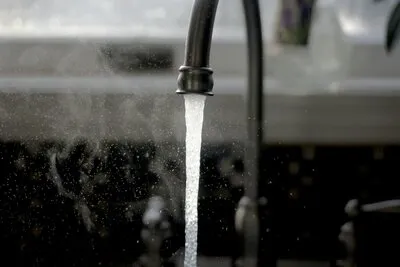 Clear water flowing from a kitchen tap in Melbourne, showing the city's naturally soft and clean tap water supply