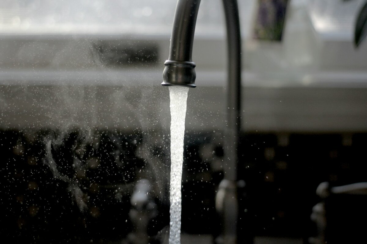 Clear water flowing from a kitchen tap in Melbourne, showing the city's naturally soft and clean tap water supply