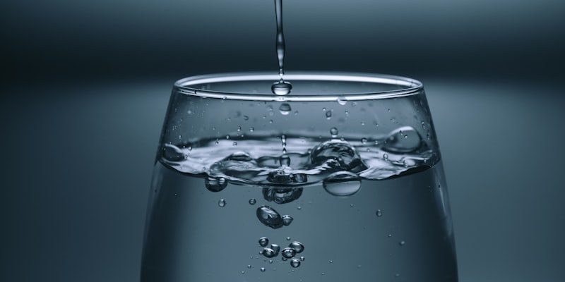 Person reading a water quality report at a kitchen table with a glass of clear tap water, representing how Australians can interpret their utility's water data