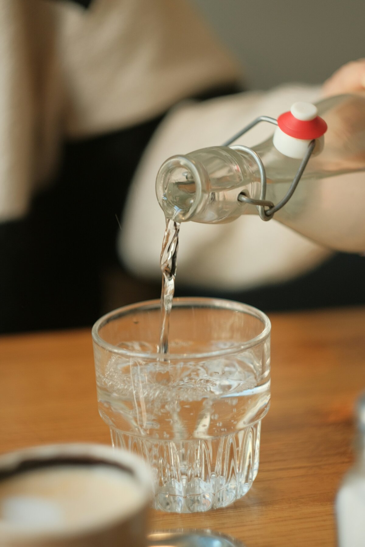 Person pouring a glass of drinking water in Adelaide, where tap water is safe but noticeably hard