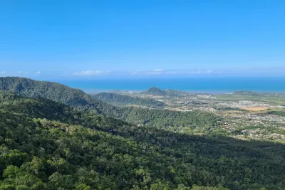 View over rainforest-covered ranges to Cairns' northern suburbs and the Coral Sea, the kind of protected catchment that supplies Cairns tap water