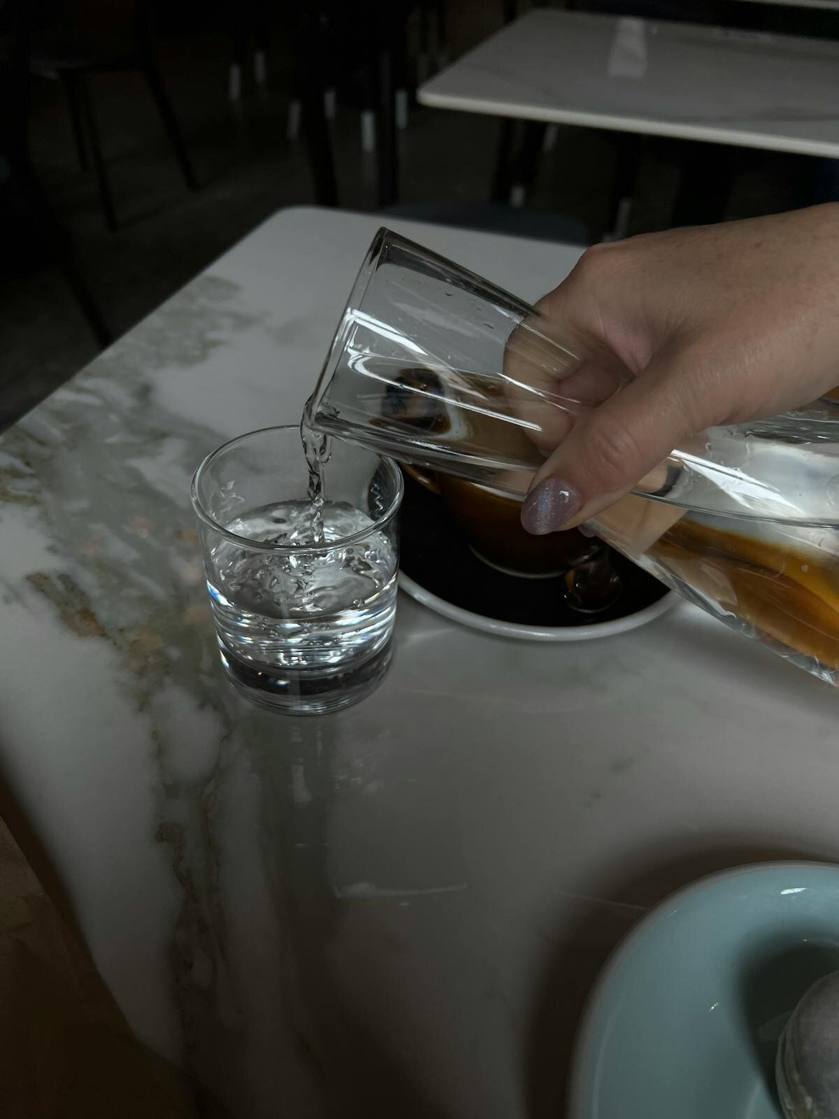 Person holding a glass of clear drinking water in a kitchen, reflecting Darwin's safe tap water supply